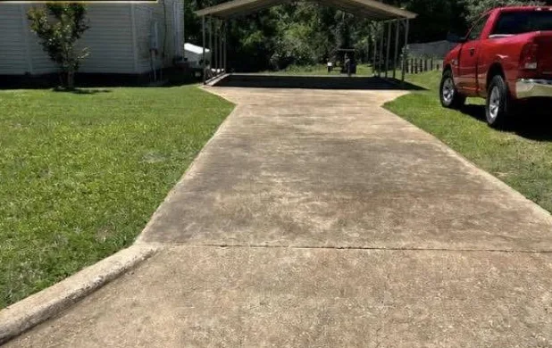 Same driveway darkened by dirt and stains before cleaning
