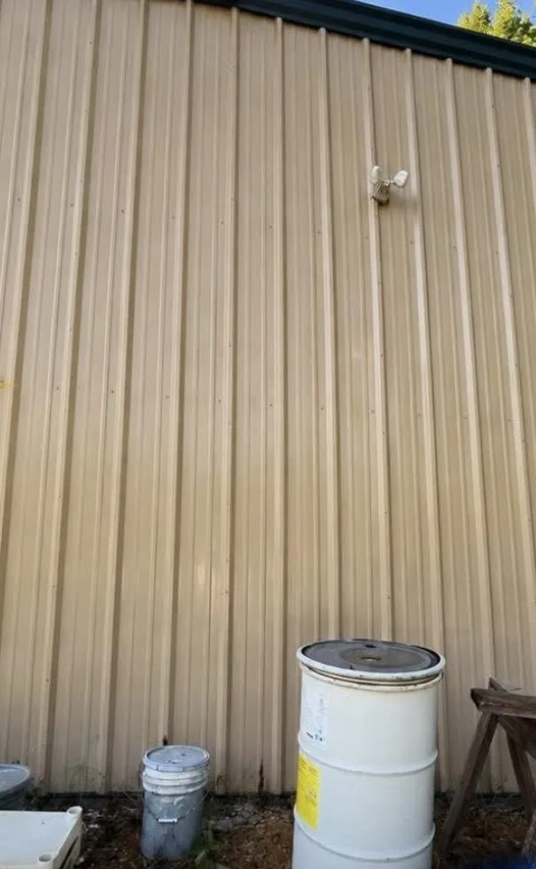 Metal building siding restored to clean tan color